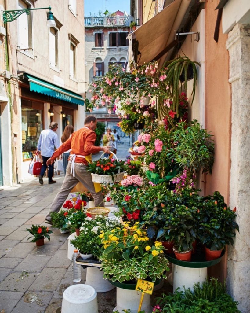 Image of florist running inside with basket of flowers