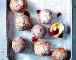 Cooked and filled jam doughnuts shown on a tray