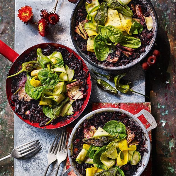 Black rice paella with artichokes, peppers and spinach