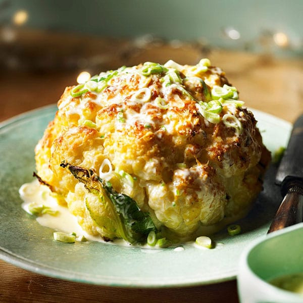 Whole roasted cauliflower with cheddar and spring onion sauce