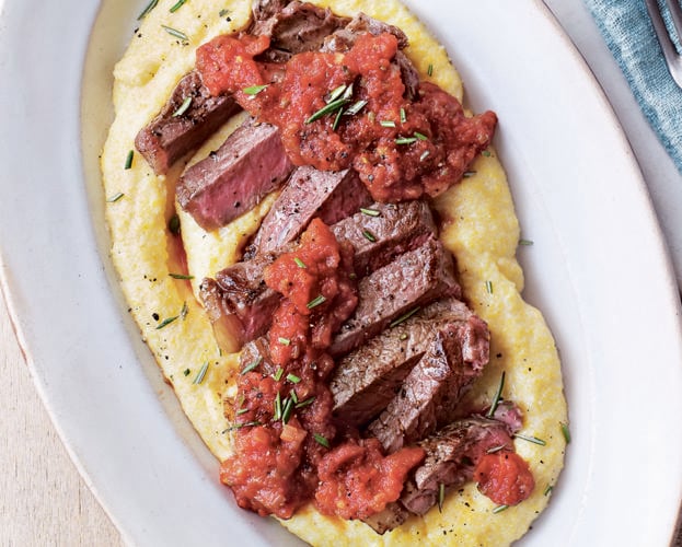 Steak with polenta and tomato and caper sauce