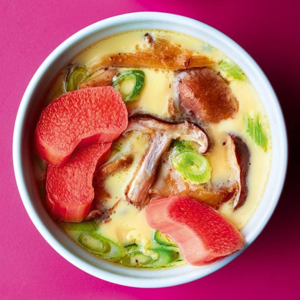 An overhead view of a bowl of savoury custard with pickled rhubarb