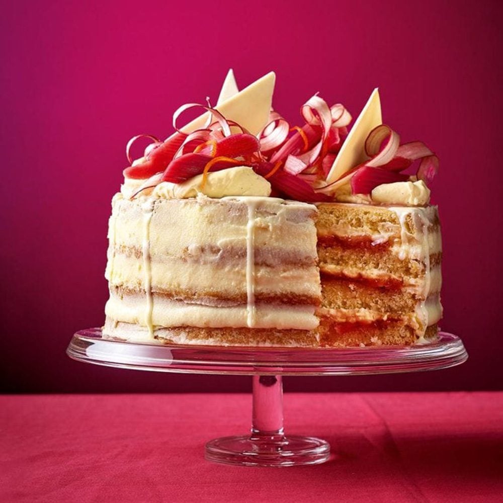 A layer cake topped with shards of white chocolate and candied rhubarb