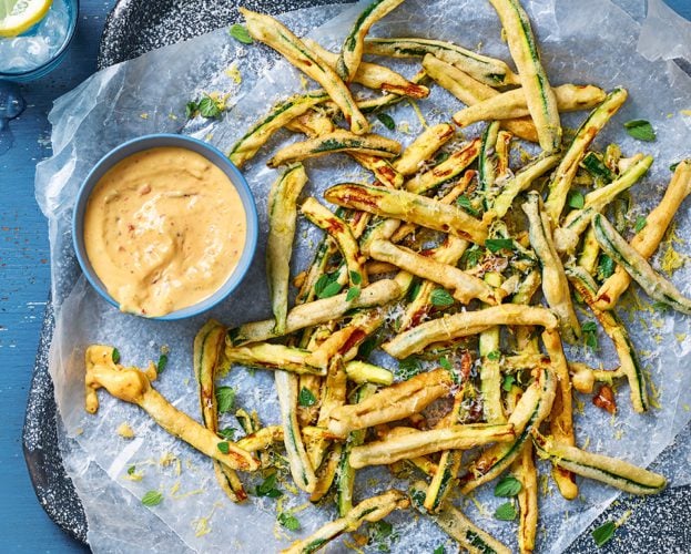 Courgette fries shown on a plate with greaseproof paper