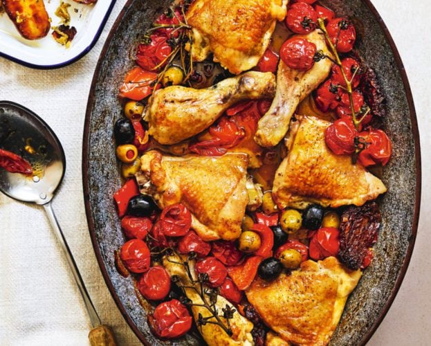 A colourful chicken provencal dish of chicken and bright red tomatoes in an oval dish