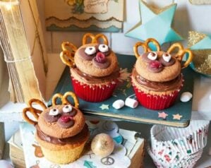 Cupcakes with a reindeer decoration shown on a festive table