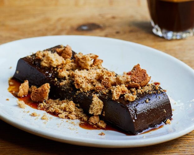 Caramel and chocolate bicerin on a platter, sprinkled with crushed amaretti biscuits