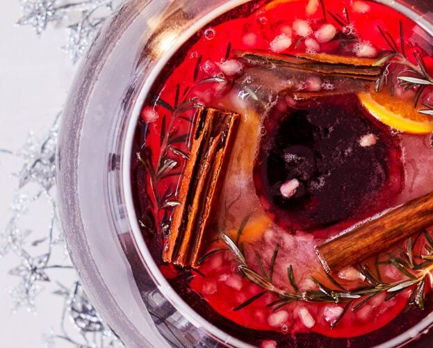 An overhead view of a punch bowl with orange slices and cinnamon sticks