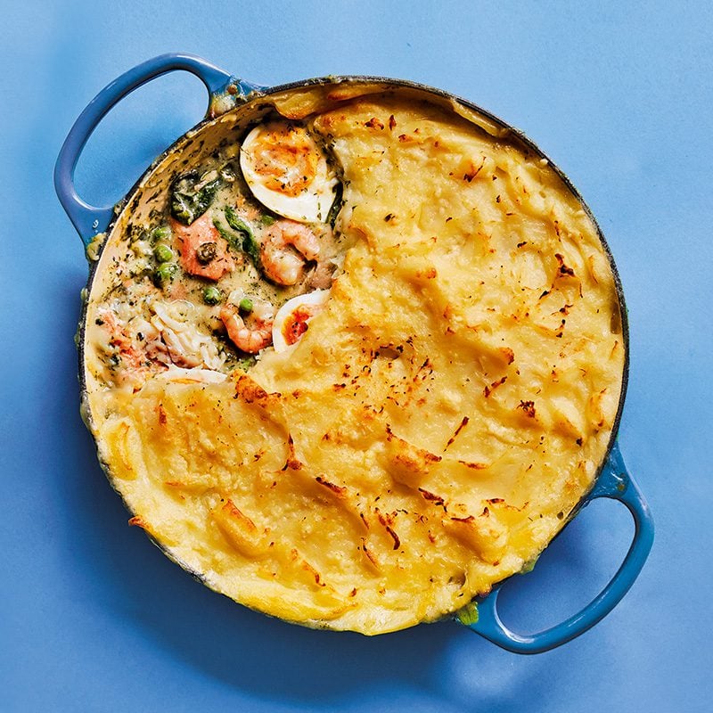 Fish pie topped with mashed potato in a circular casserole dish