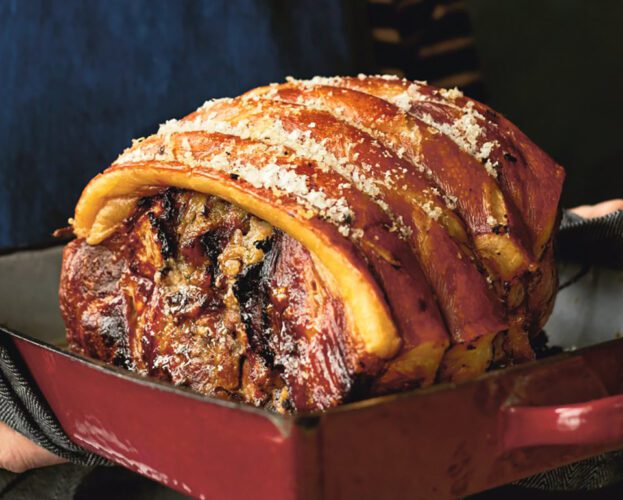 Slow-cooked shoulder of pork in a roasting tray topped with crackling