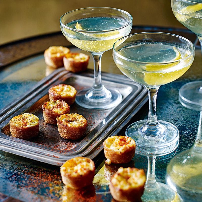 Mini cheese and onion cups pictured with cocktails