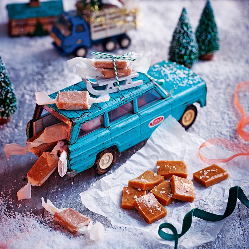 Salted caramel sweets wrapped in twists of paper and placed on a toy car