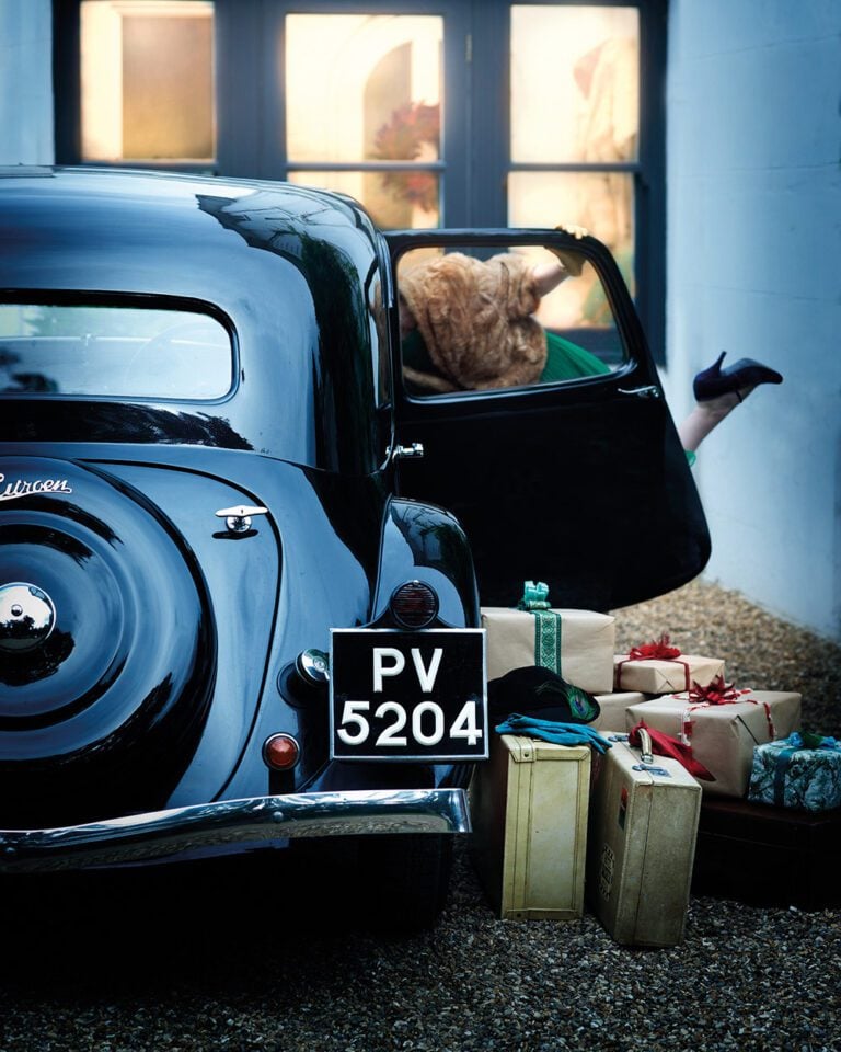 A vintage car being packed with presents