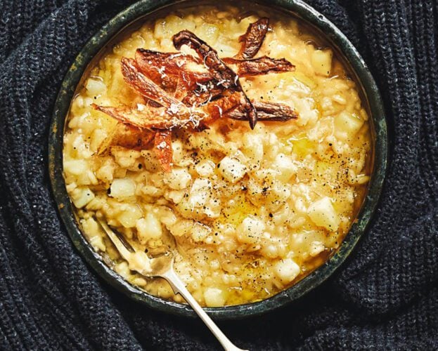 A bowl of golden risotto, with a spoon in