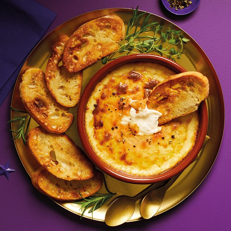 Hot cheese dip in an earthenware dish served with bread