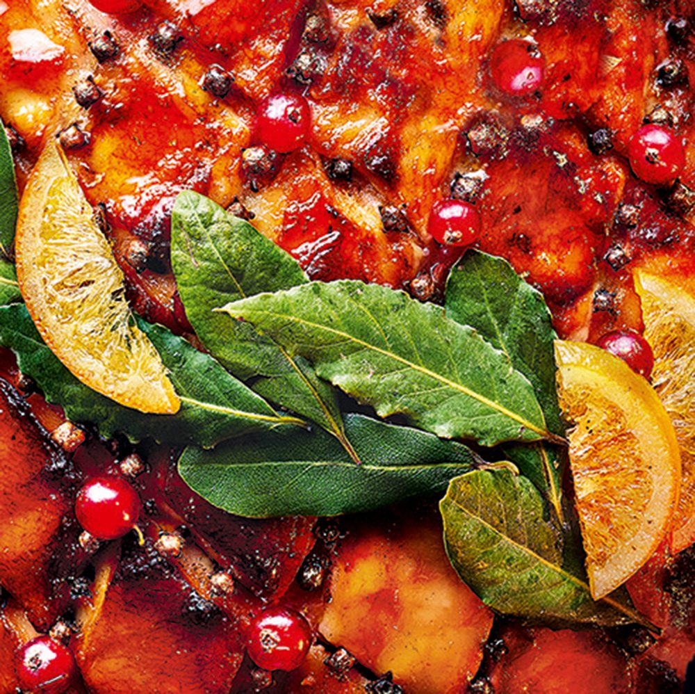 A close-in view of crispy ham skin with fruits and bay leaves