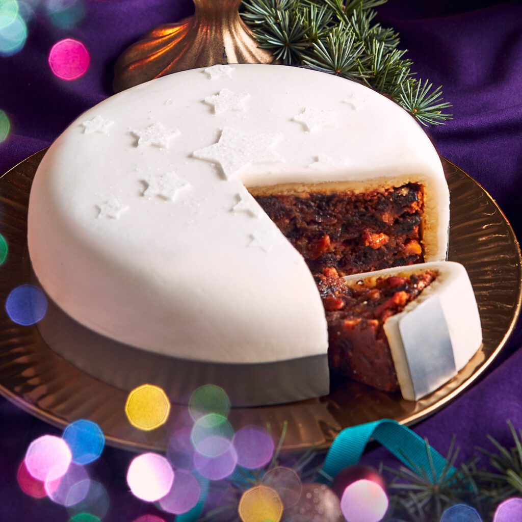 A white iced Christmas cake with a slice removed
