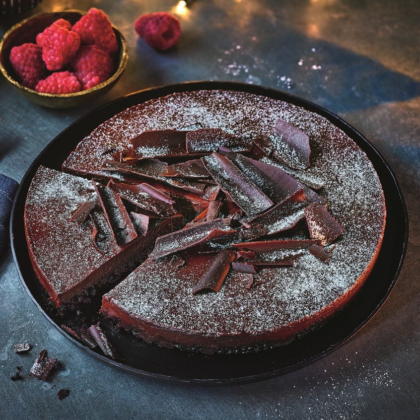 A chocolate torte topped with shards of dark chocolate