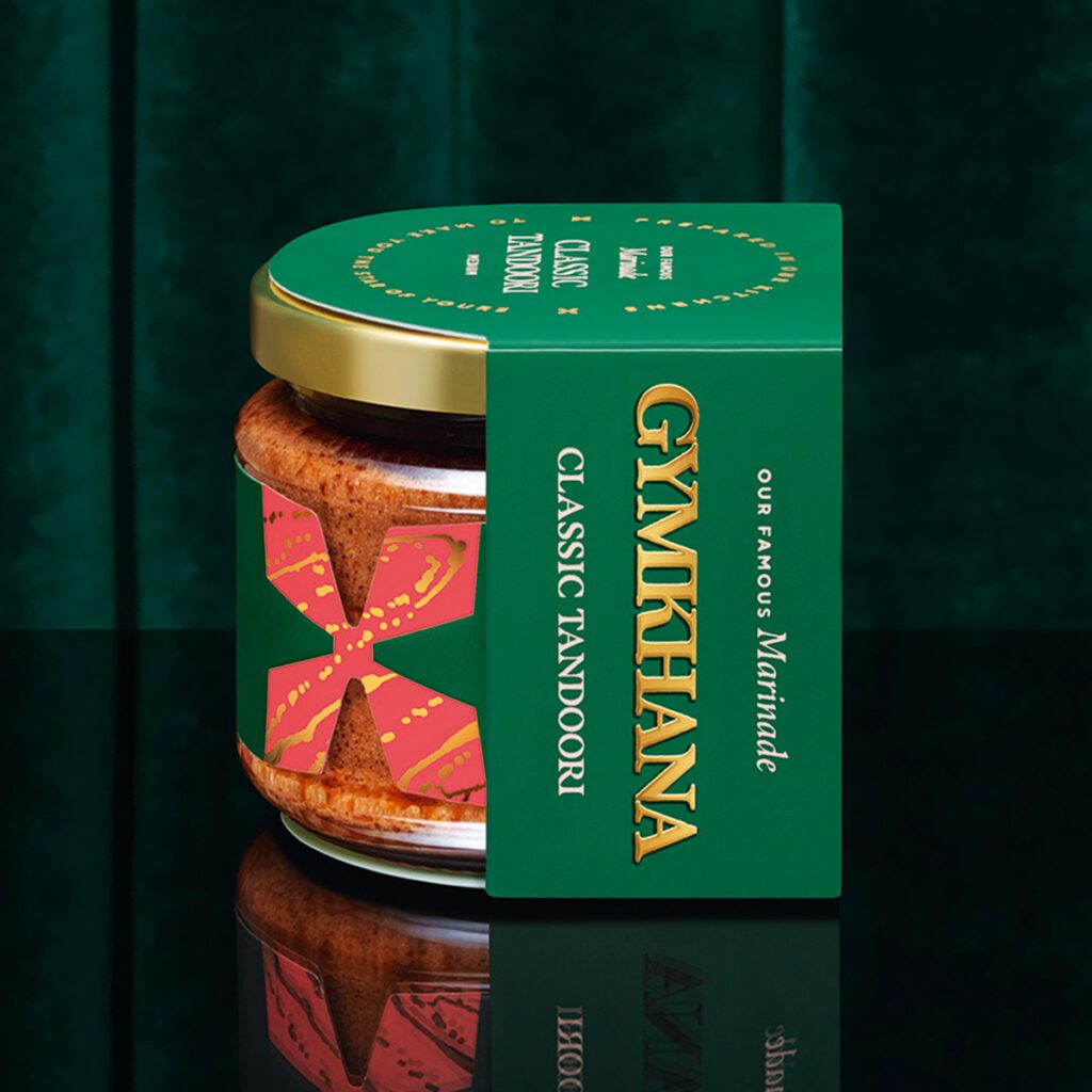 A jar of curry paste from restaurant Gymkhana against a dark green background