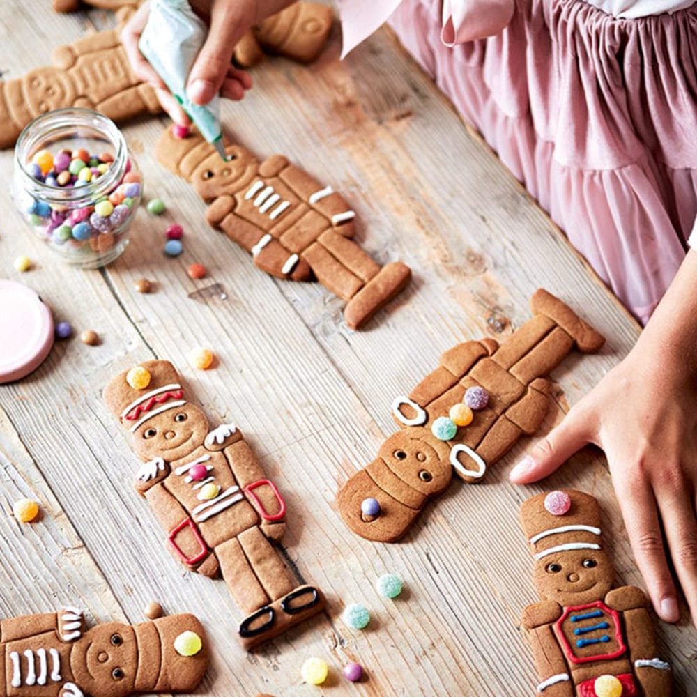 A child's hands decorating gingerbread biscuits