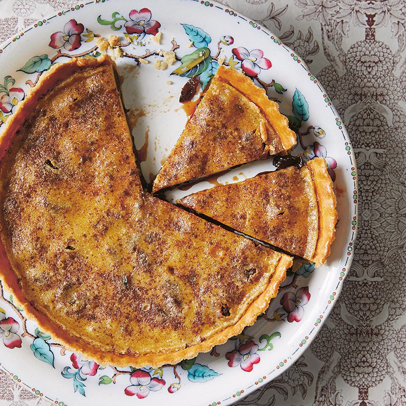 Image of a prune tart from cookbook A Whisper of Cardamom by Eleanor Ford