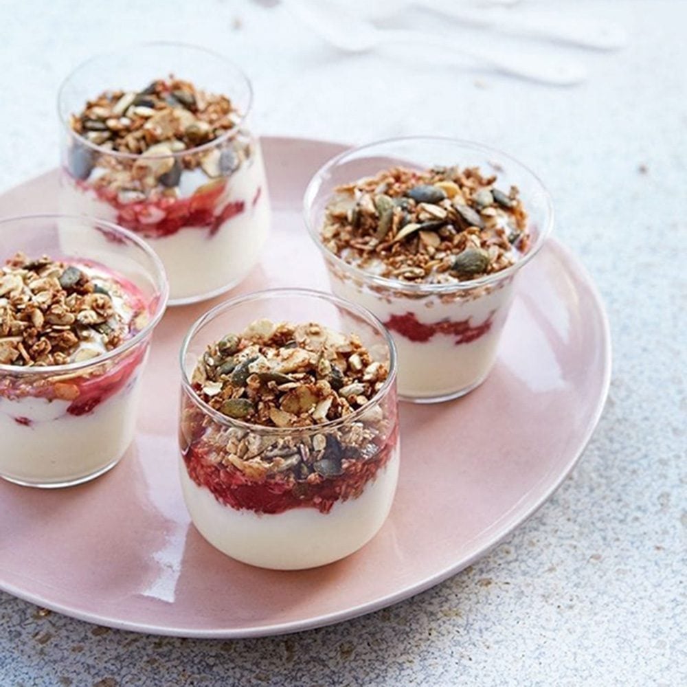 Yogurt pots topped with fruit compote, oats, nuts and seeds