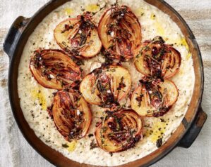 Caramelised onion halves on a bed of savoury porridge