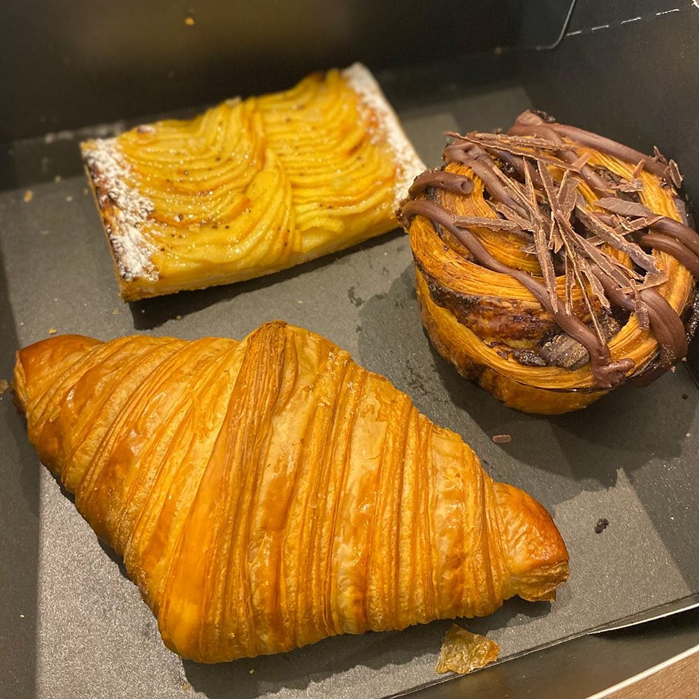A selection of pastries, including a croissant and apple tart