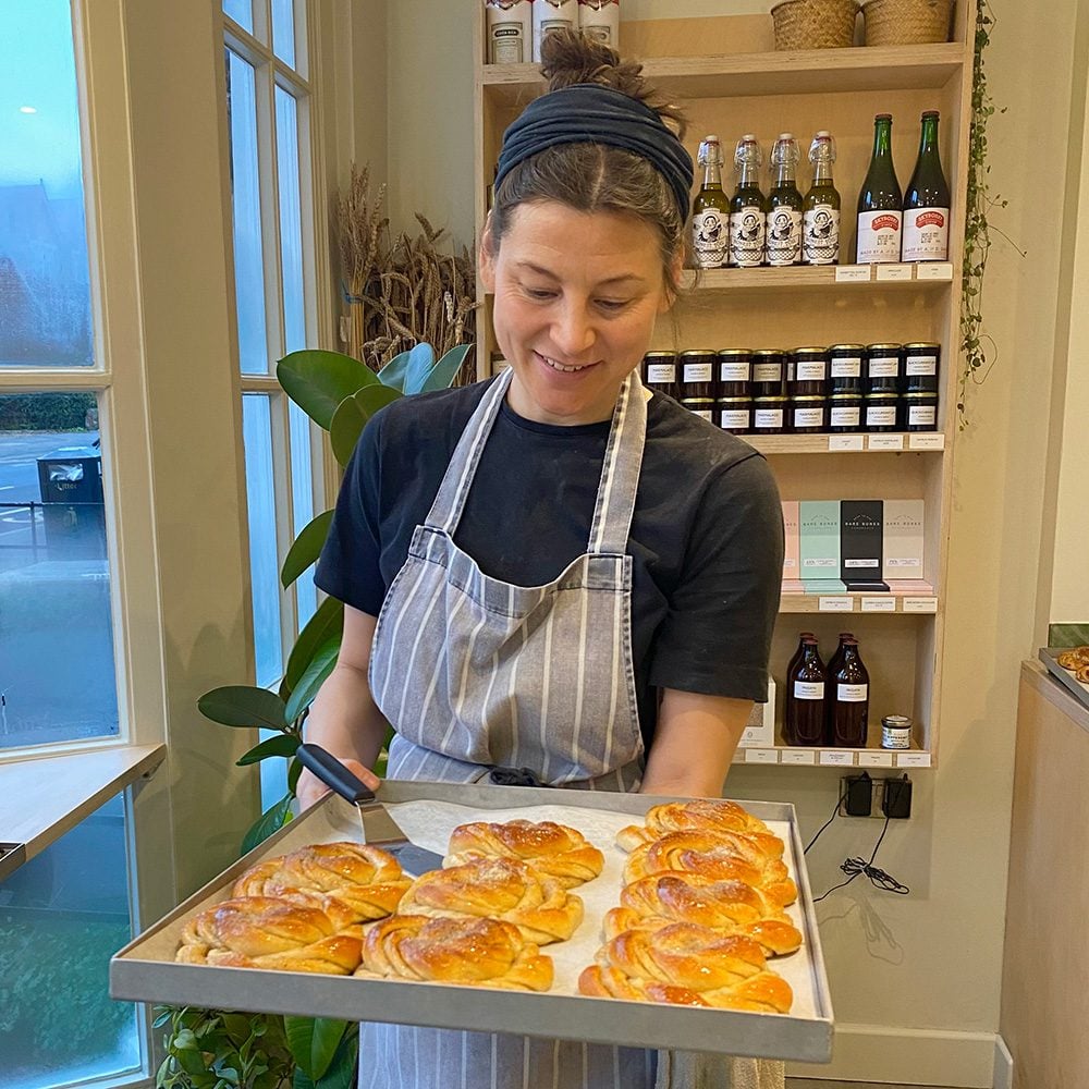 Baker Kate Hamblin of Hamblin Bread holding a tray of cardamom buns