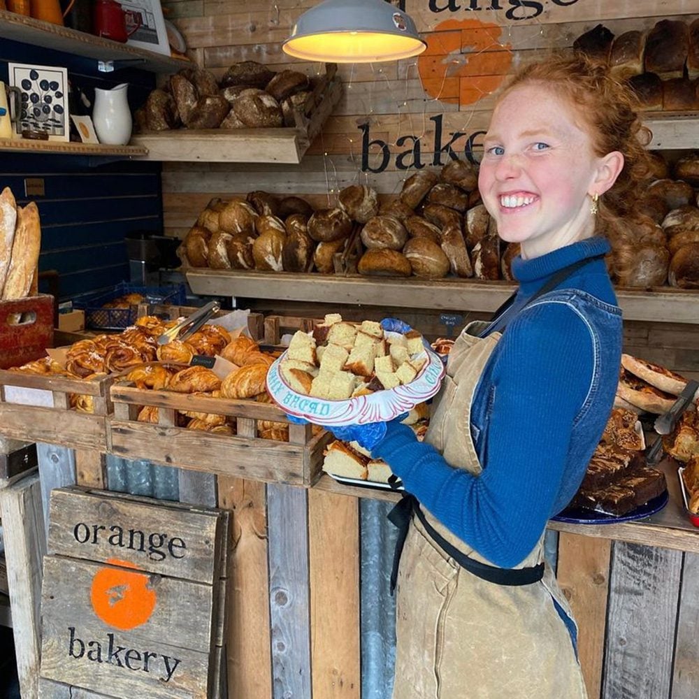 Kitty Tait standing in front of the counter at her bakery, Orange Bakery, in Watlington, Oxfordshire