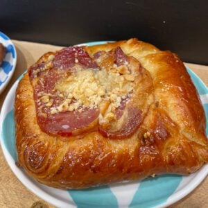 A bronze pastry topped with bacon