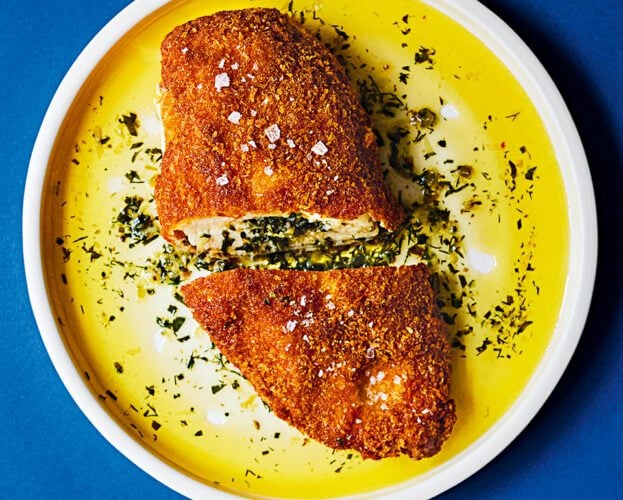 Overhead view of the best chicken kyiv, sliced in half and with garlic butter oozing