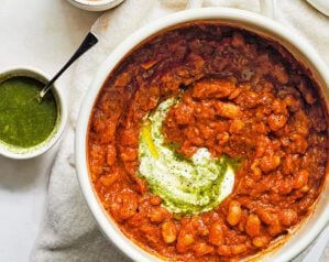 A pot of masala baked beans swirled with with green coriander chutney