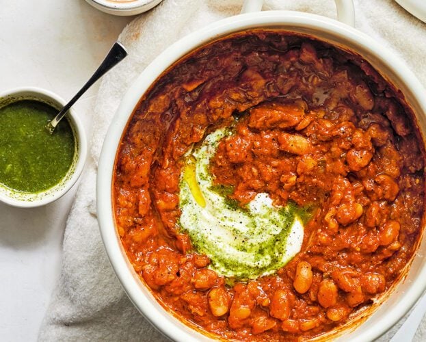 A pot of masala baked beans swirled with with green coriander chutney