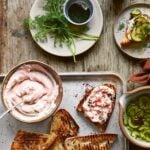 A bowl of taramasalata, next to taramasalata spread on toast